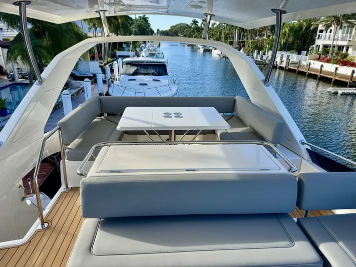 Roosterfish Yacht Photos Pics Aquila 44 yacht deck with seating and table, docked in a scenic canal, 2022 model.