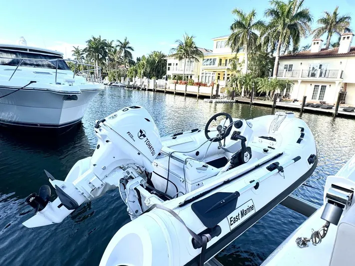 Roosterfish Yacht Photos Pics Aquila 44 yacht docked by waterfront homes, featuring a small motorboat.