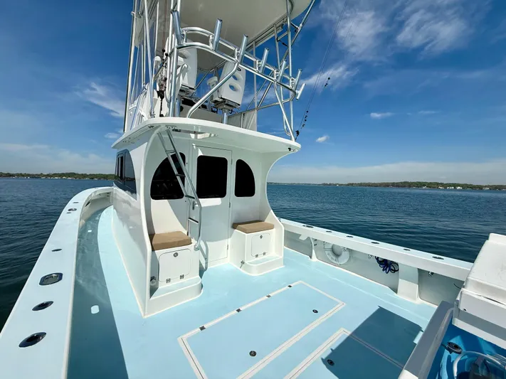 Reel Conversation Yacht Photos Pics 2023 Millennium Marine NuWave 37 boat on calm water under clear blue sky.