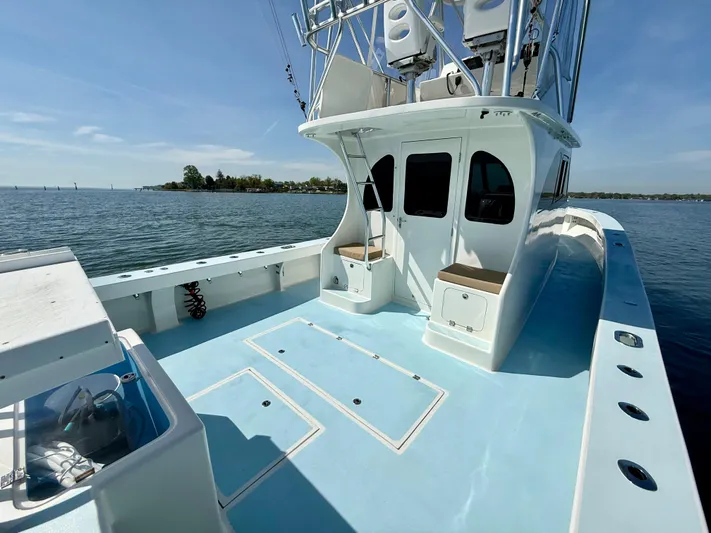 Reel Conversation Yacht Photos Pics 2023 Millennium Marine NuWave 37 boat on calm water, featuring spacious deck and seating.