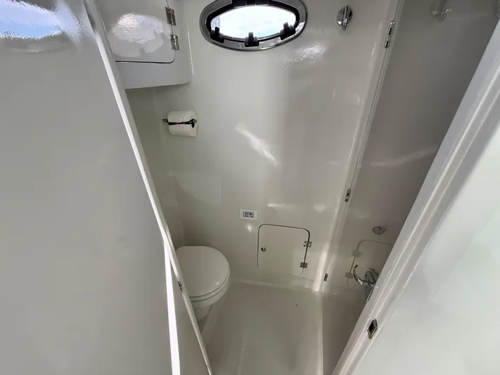 Reel Conversation Yacht Photos Pics 2023 Millennium Marine NuWave 37 boat bathroom with toilet and porthole window.