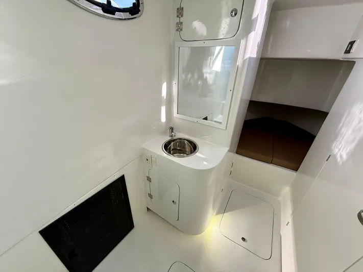 Reel Conversation Yacht Photos Pics 2023 Millennium Marine NuWave 37 interior with sink and storage, featuring sleek white design.