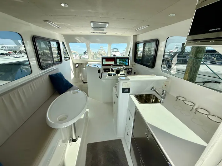 Reel Conversation Yacht Photos Pics Interior of 2023 Millennium Marine NuWave 37 boat with modern helm and seating area.