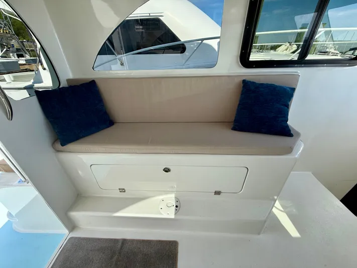 Reel Conversation Yacht Photos Pics 2023 Millennium Marine NuWave 37 interior with cushioned seating and blue pillows.