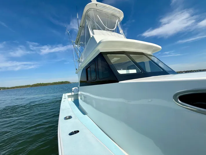 Reel Conversation Yacht Photos Pics 2023 Millennium Marine NuWave 37 boat on calm water under clear blue sky.