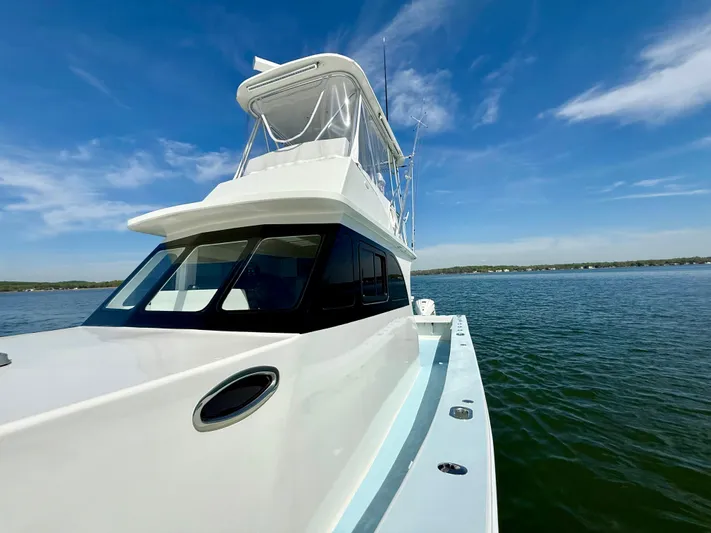 Reel Conversation Yacht Photos Pics 2023 Millennium Marine NuWave 37 boat on calm water under clear blue sky.