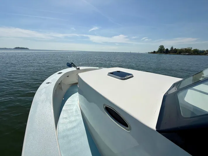 Reel Conversation Yacht Photos Pics 2023 Millennium Marine NuWave 37 boat on calm water under clear sky.