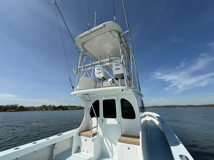 Reel Conversation Yacht Photos Pics 2023 Millennium Marine NuWave 37 boat on calm water under clear blue sky.
