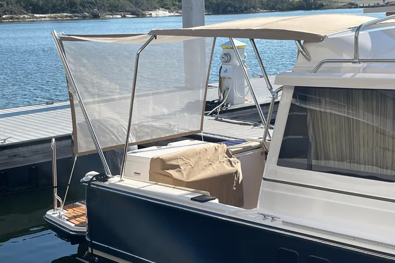  Yacht Photos Pics 2026 Ranger Tugs R-27 docked, featuring a covered deck and scenic waterfront view.