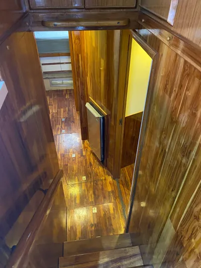  Yacht Photos Pics 1987 Bertram 50 Convertible interior with polished wood paneling and flooring.