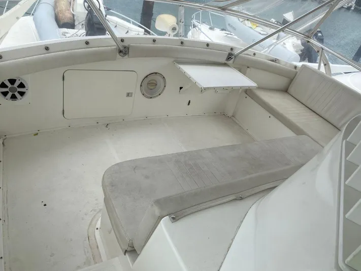  Yacht Photos Pics 1987 Bertram 50 Convertible boat interior with white seating and table, docked at marina.