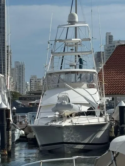  Yacht Photos Pics 1987 Bertram 50 Convertible yacht docked in a marina, surrounded by city buildings.