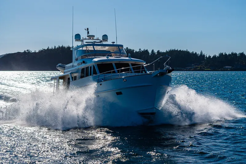Grand Finale Yacht Photos Pics 2007 Grand Banks 59 Aleutian Raised Pilothouse cruising on open water, creating a dynamic splash.