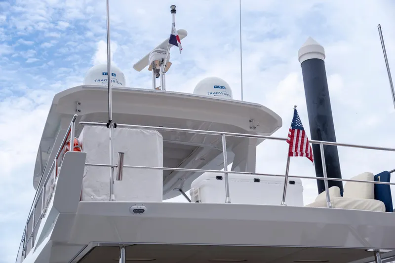  Yacht Photos Pics Azimut 66 FLY 2017 yacht deck with radar, flag, and clear sky background.