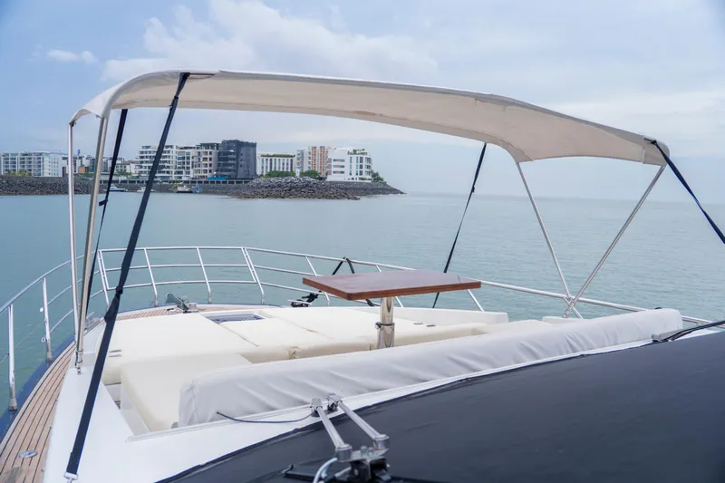  Yacht Photos Pics Luxurious 2017 Azimut 66 FLY yacht with sunshade, overlooking serene coastal view.