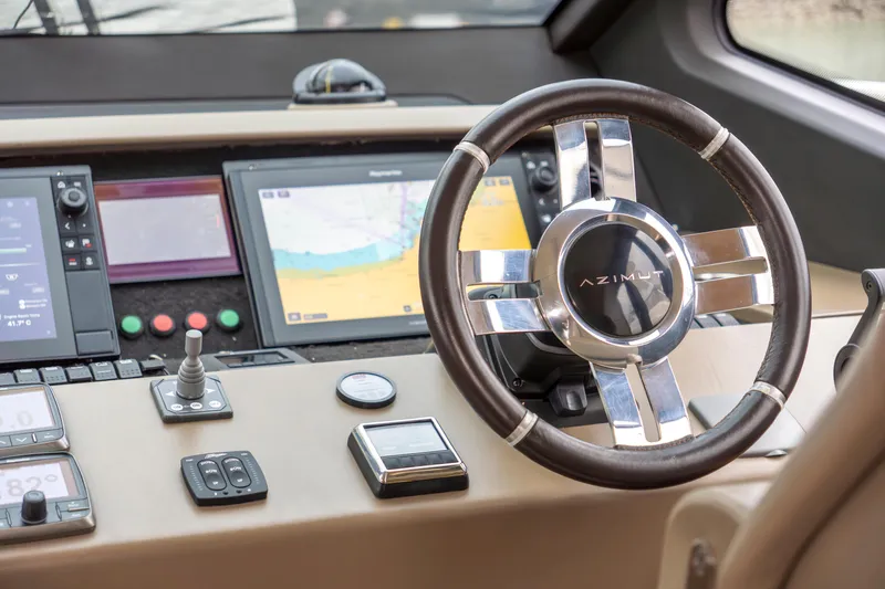 Yacht Photos Pics Steering wheel and dashboard of 2017 Azimut 66 FLY yacht with navigation screens.