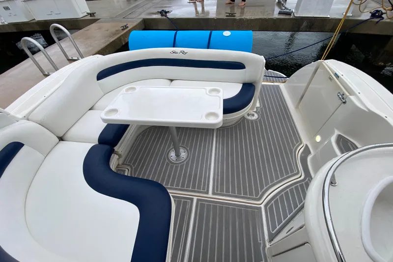  Yacht Photos Pics 2004 Sea Ray 340 Sundancer cockpit with white and blue seating, table, and gray flooring.
