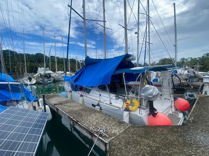 Sv Tonic III Yacht Photos Pics Beneteau Oceanis 41.1 sailboat docked, covered with blue tarps, in a marina setting.
