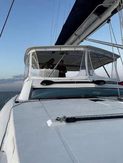 Oe Hani Yacht Photos Pics 2018 Leopard 58 yacht sailing with two people on deck, clear sky background.