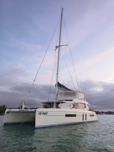 Oe Hani Yacht Photos Pics 2018 Leopard 58 catamaran sailing on calm waters at sunset.
