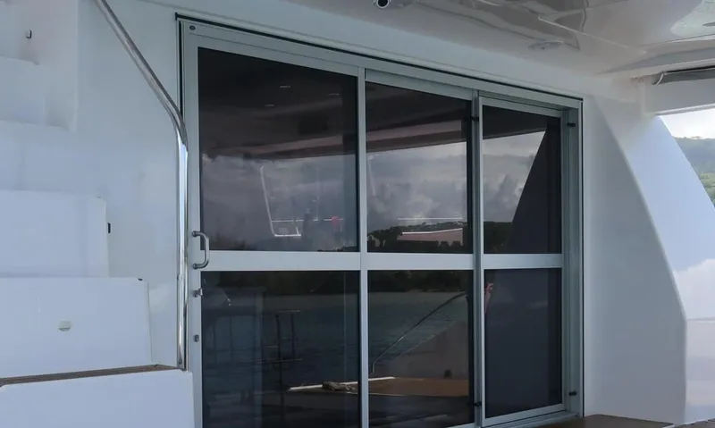 Oe Hani Yacht Photos Pics Sliding glass doors on a 2018 Leopard 58 yacht, with white stairs and railing.