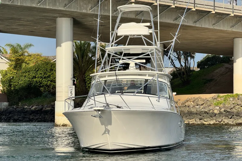  Yacht Photos Pics 2012 Viking 42 Open yacht under a bridge, surrounded by greenery and calm water.