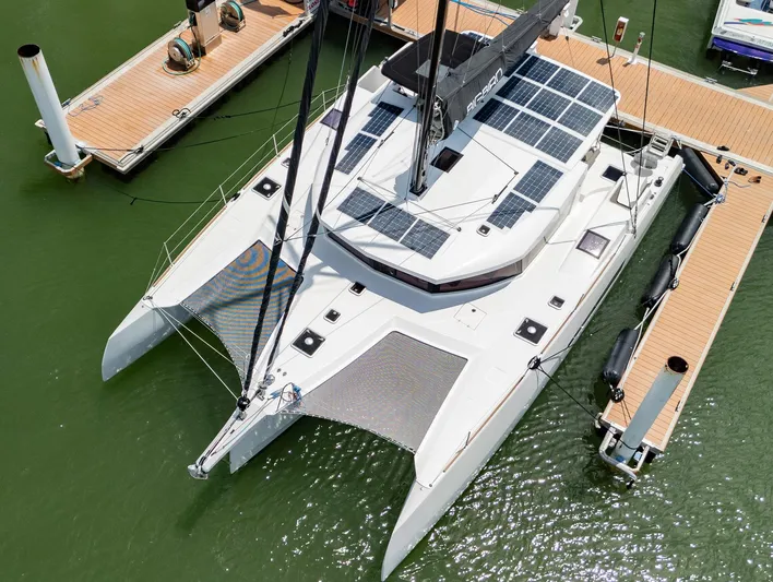 Big Bird Yacht Photos Pics 2021 NEEL 47 trimaran docked, featuring solar panels and spacious deck.