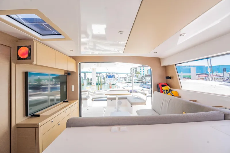 Big Bird Yacht Photos Pics Interior of 2021 NEEL 47 trimaran with modern design, featuring a spacious lounge and large windows.