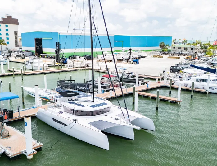 Big Bird Yacht Photos Pics NEEL 47 trimaran docked at marina, 2021 model, with blue warehouse in background.