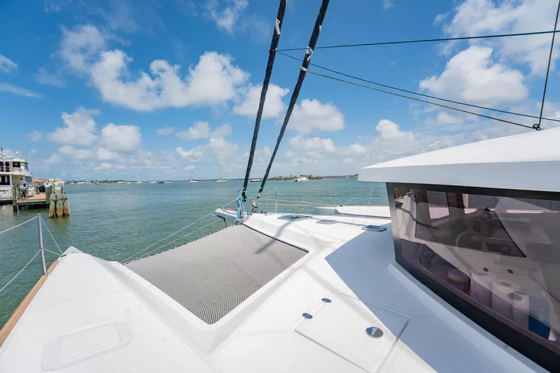 Big Bird Yacht Photos Pics NEEL 47 trimaran on water, showcasing deck and netting under a clear blue sky.