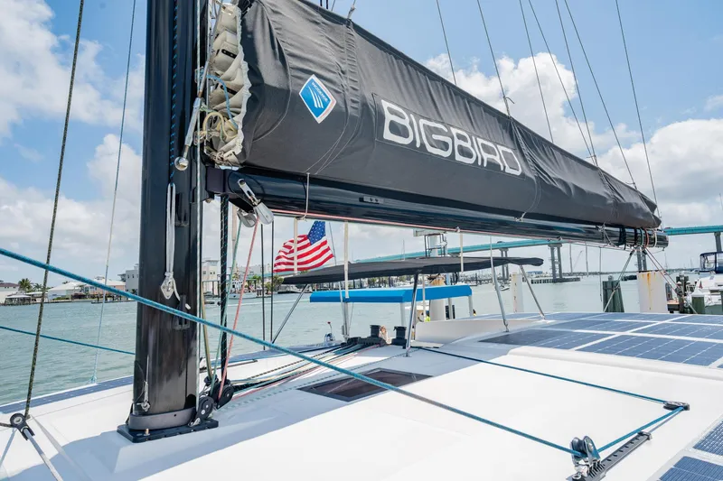 Big Bird Yacht Photos Pics Trimaran NEEL 47 "Bigbird" with American flag, docked in a sunny marina, 2021 model.