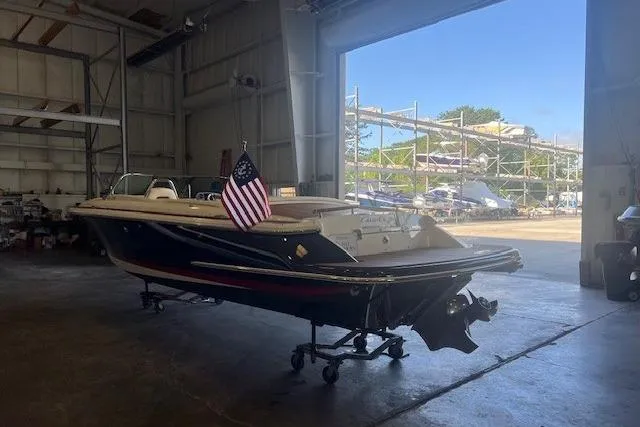  Yacht Photos Pics 2024 Chris-Craft Launch 27 boat in a warehouse, American flag displayed.