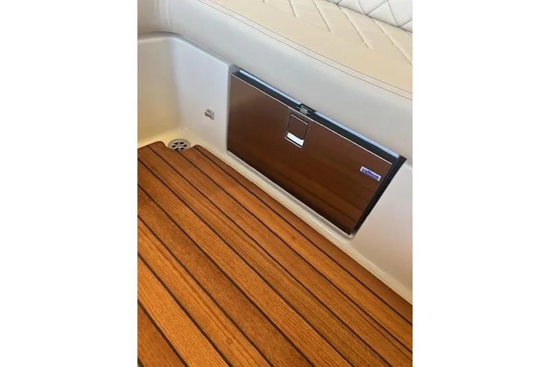  Yacht Photos Pics 2024 Chris-Craft Launch 27 interior with teak flooring and built-in cooler.