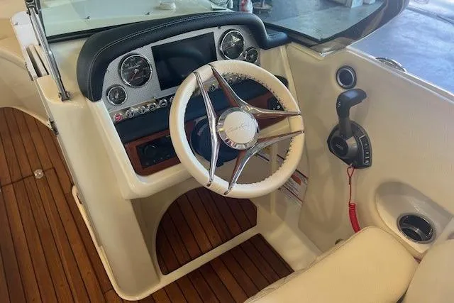  Yacht Photos Pics 2024 Chris-Craft Launch 27 cockpit with wooden flooring and modern steering controls.