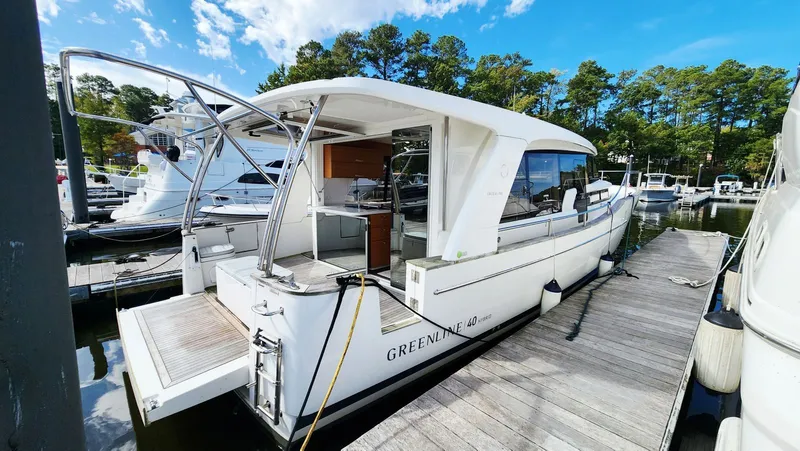 Sea-solar Sue & Lectric Lee Yacht Photos Pics 2022 Greenline 40 yacht docked at marina, surrounded by trees and clear blue sky.