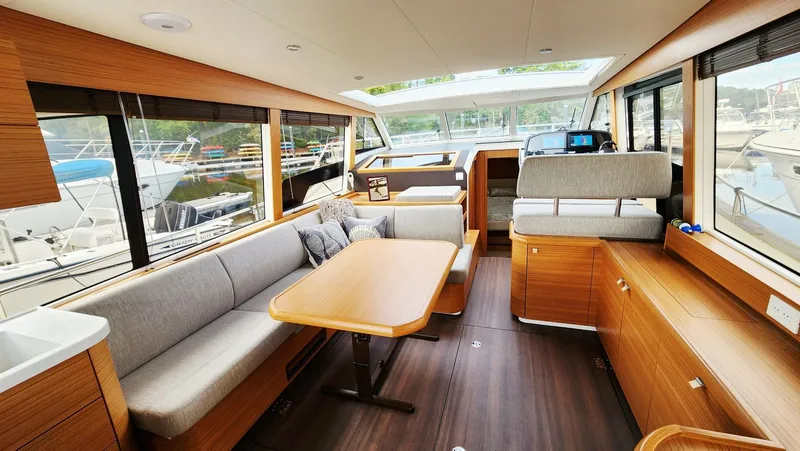 Sea-solar Sue & Lectric Lee Yacht Photos Pics Luxurious interior of 2022 Greenline 40 yacht with modern wood finish and spacious seating.