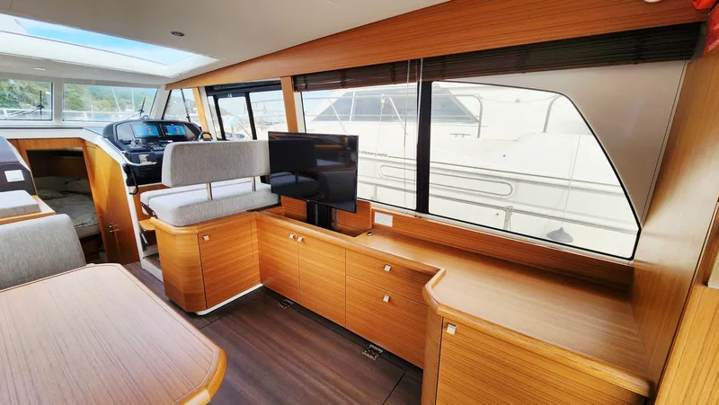 Sea-solar Sue & Lectric Lee Yacht Photos Pics Interior of 2022 Greenline 40 yacht with modern wood finish and seating area.