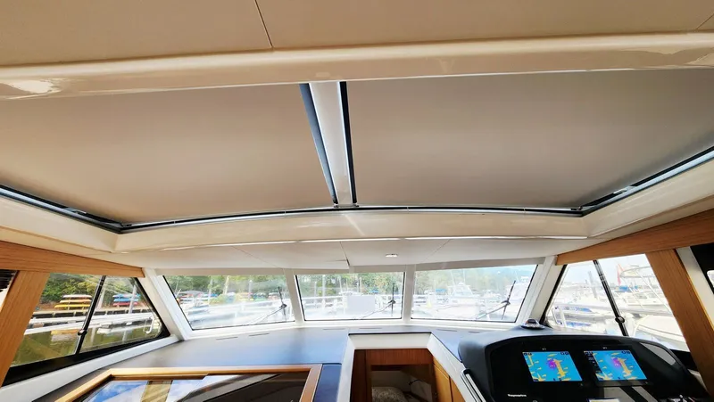 Sea-solar Sue & Lectric Lee Yacht Photos Pics Interior view of 2022 Greenline 40 yacht cockpit with navigation screens and panoramic windows.