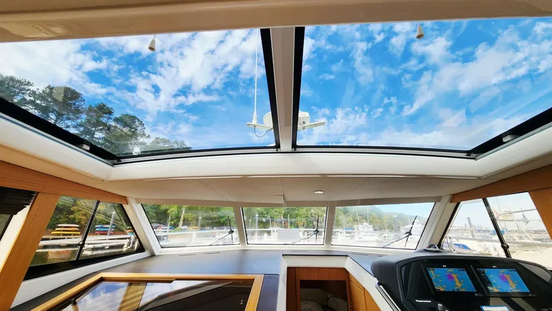 Sea-solar Sue & Lectric Lee Yacht Photos Pics Interior view of 2022 Greenline 40 yacht with panoramic windows and navigation screens.