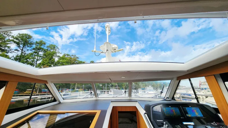 Sea-solar Sue & Lectric Lee Yacht Photos Pics Interior view of 2022 Greenline 40 yacht cockpit with panoramic windows and navigation screens.
