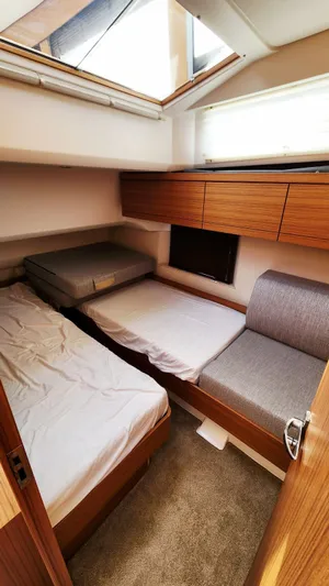 Sea-solar Sue & Lectric Lee Yacht Photos Pics Interior of 2022 Greenline 40 yacht cabin with twin beds and wooden cabinetry.