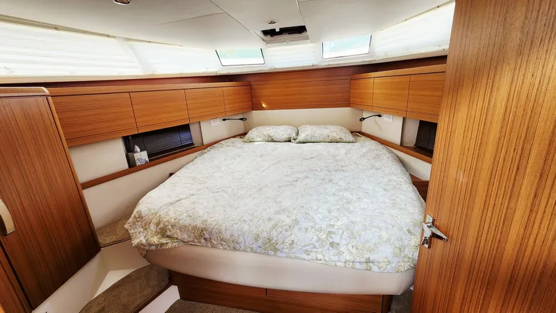 Sea-solar Sue & Lectric Lee Yacht Photos Pics Luxurious bedroom interior of 2022 Greenline 40 yacht with wood paneling and cozy bedding.