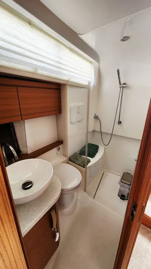 Sea-solar Sue & Lectric Lee Yacht Photos Pics 2022 Greenline 40 yacht bathroom with modern fixtures, wooden cabinetry, and compact shower area.