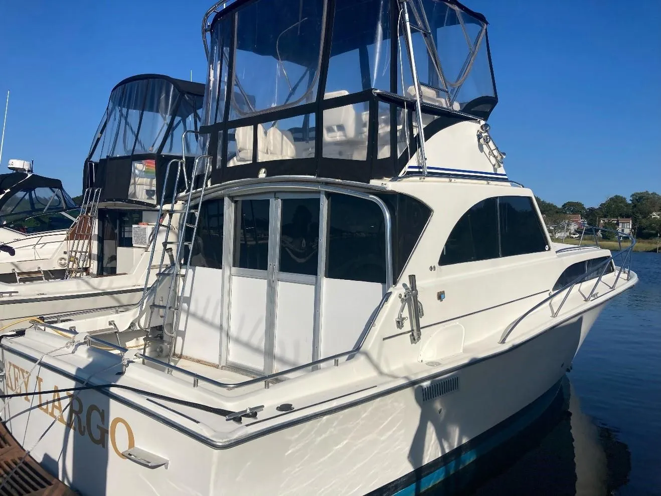 1969 Pacemaker 33 boat docked, featuring a flybridge and white exterior.