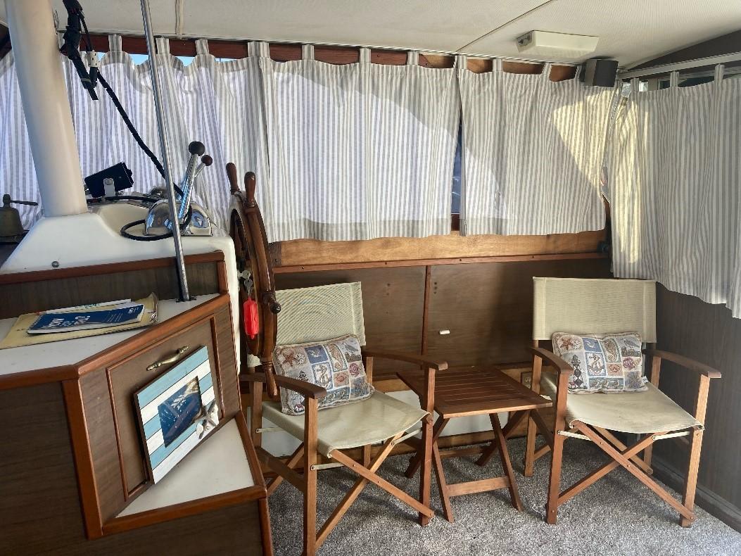 1969 Pacemaker 33 boat interior with chairs, table, and nautical decor.