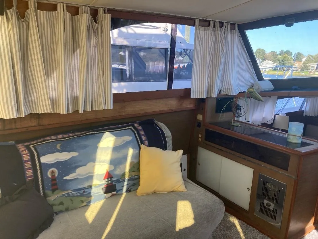 Interior of a 1969 Pacemaker 33 boat with cozy seating and nautical decor.