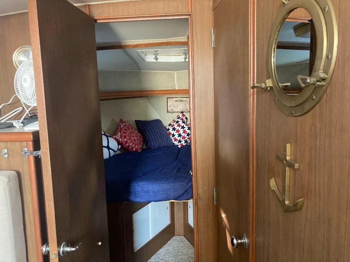 Cozy cabin interior of 1969 Pacemaker 33 boat with nautical decor and bedding.