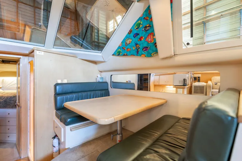 Shore Leave Yacht Photos Pics 1998 Carver 355 Aft Cabin interior with dining area, teal seating, and colorful fish curtain.