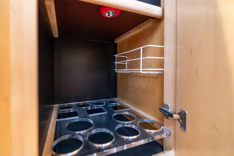 Shore Leave Yacht Photos Pics 1998 Carver 355 Aft Cabin interior cabinet with cup holders and wire rack.