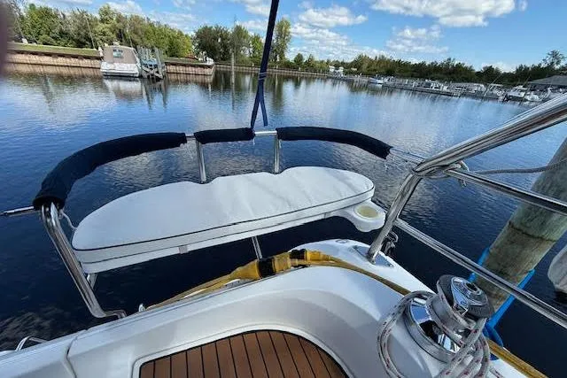  Yacht Photos Pics 2005 Hunter 38 sailboat cockpit with cushioned seating, docked by a serene lake.